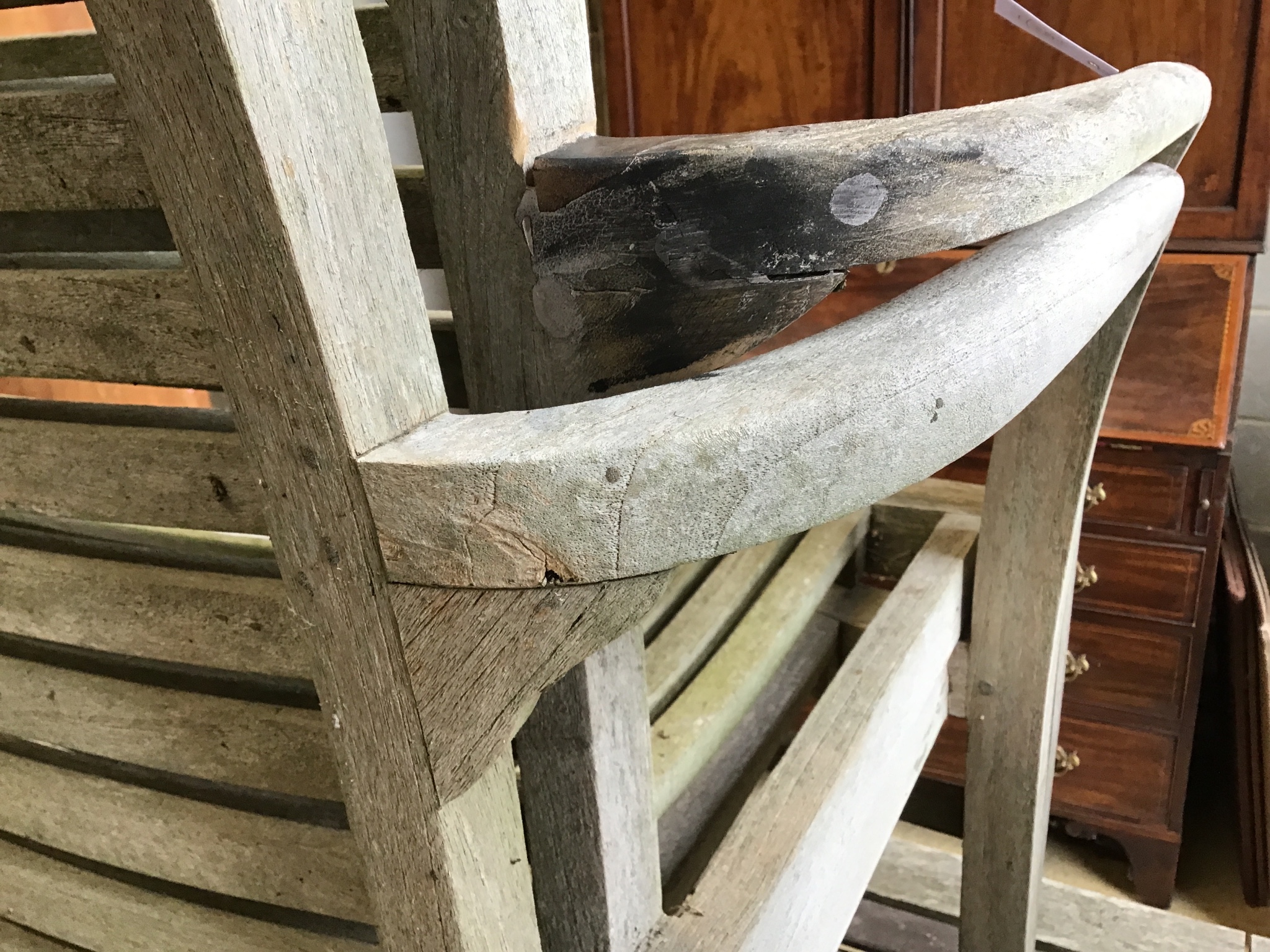 A weathered teak oval extending garden table, 242 cm extended, width 102 cm, height 73 cm and six stacking elbow chairs.